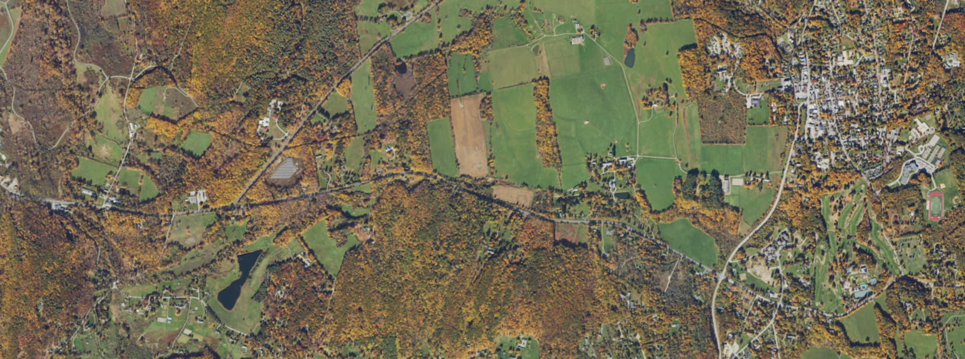 Aerial survey view over central Dutchess County, NY, showing farmland, woodlots, ponds and the village of Millbrook
