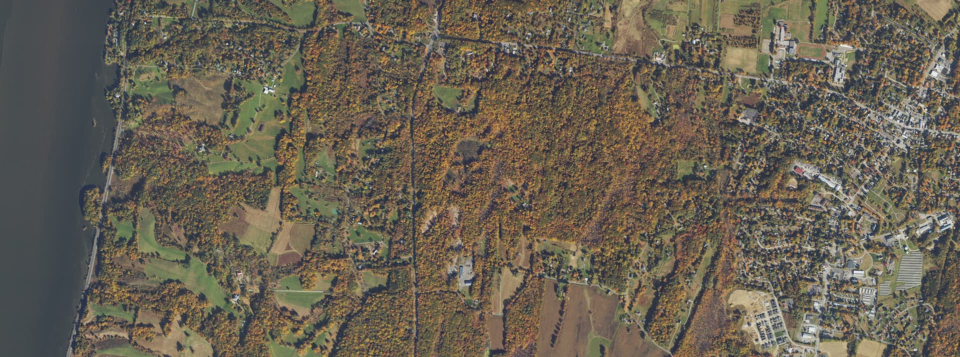 Aerial survey view over Red Hook, NY, showing the road network, tree cover and surrounding countryside