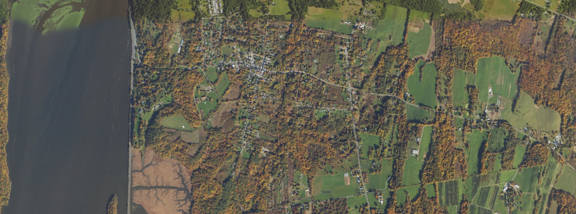 Aerial survey view over Tivoli, NY, showing the village street grid, the Hudson River and Tivoli Bays
