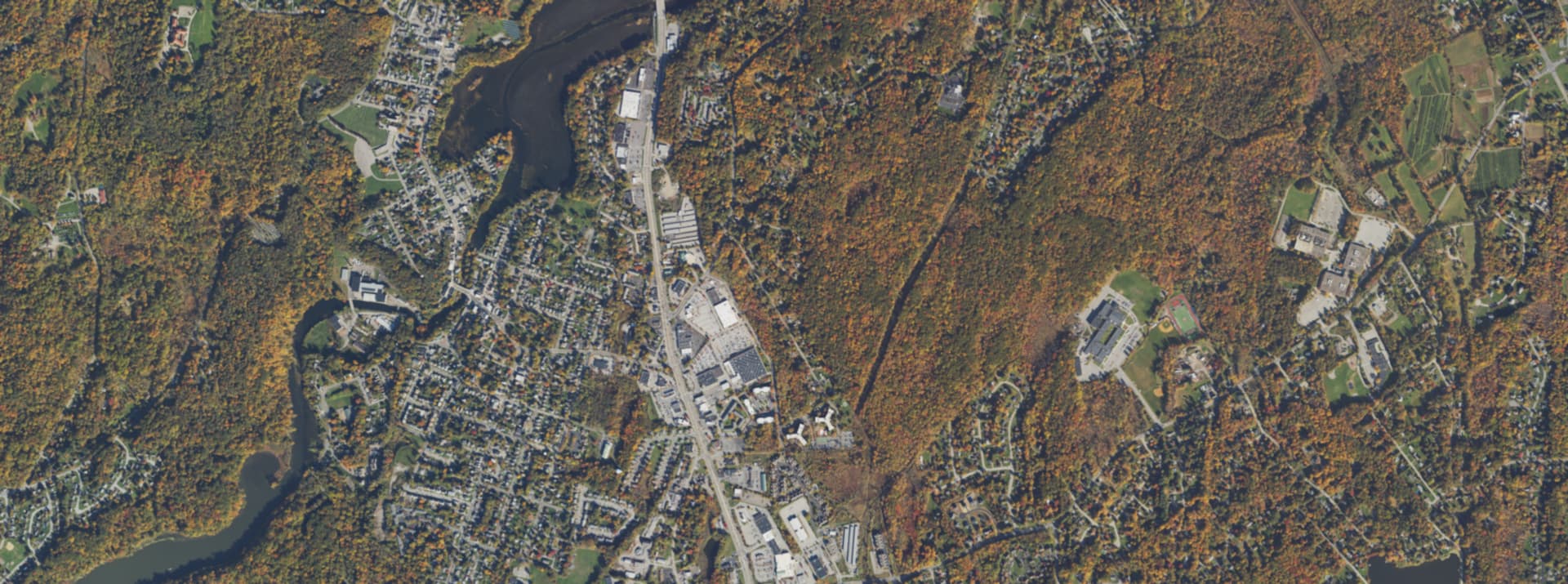 Aerial survey view over Wappingers Falls, NY, showing the village street grid, Wappinger Creek and surrounding tree cover
